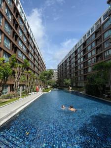 two people swimming in a swimming pool in a building at Dcondo Creek Phuket 2BR in Kathu