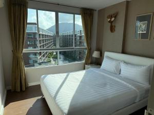a bedroom with a bed and a large window at Dcondo Creek Phuket 2BR in Kathu +13 photos