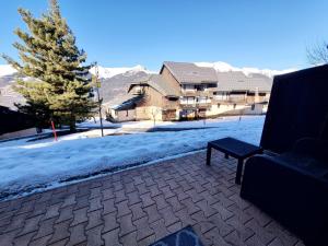 a couch sitting on a patio in the snow at Charmant Appartement Ski-In à La Plagne - 6 Pers. - FR-1-755-41 in Aime La Plagne