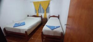 2 Betten in einem Zimmer mit blauen Handtüchern darauf in der Unterkunft Hostal el rincón de cusi in Mina Pirquitas