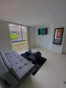 una sala de estar con un sofá y una mesa en Apartamento en Manizales, en Manizales