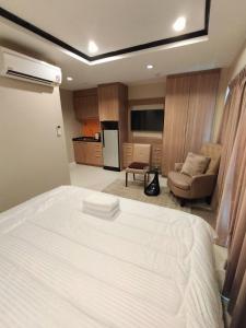 Un dormitorio con una gran cama blanca y un sofá. en New Nordic VIP 6, en Pattaya South
