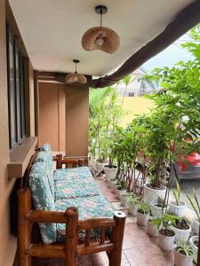 a porch with a table and chairs and potted plants at Chic &Cozy 3Bedroom House in Agus