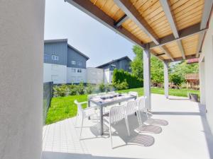 a patio with a table and white chairs at Villa neuve aux Rousses, proche centre, jusqu'à 12 personnes - FR-1-834-5 in Les Rousses