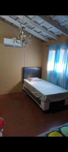 a bedroom with a bed and a chandelier at La esperanza oficial in Encarnación