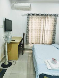 a bedroom with a bed and a desk with a television at st theresas homes in Lagos