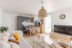 a living room with a white couch and a table at Luxury apartment near Paris in Bois-Colombes +30 photos