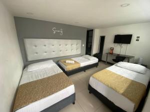 una camera d'albergo con due letti e una televisione di Serenity by noa hotels a Bogotá