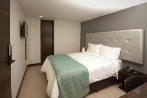 una camera da letto con un letto grande e una televisione di Serenity by noa hotels a Bogotá