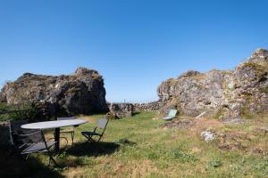a picnic table and chairs on a hill with rocks at Le p'tit pelet in Fraissinet-de-Fourques