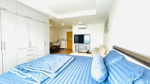 une chambre avec un grand lit avec des draps bleus dans l'établissement GRAND HYCHARMS serviced STUDIO, à Quy Nhơn