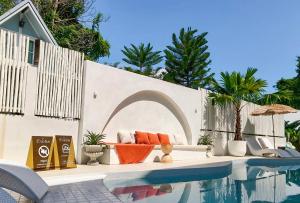 a living room with a couch next to a pool at Evelia Kohsamed in Ao Phutsa