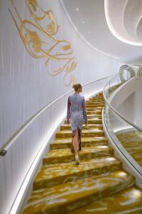 a woman is walking down the stairs of a building at Mandarin Oriental, Munich in Munich