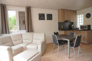 una sala de estar con un sofá y una mesa en Chalet d'Aventures, en Durbuy 4 fotos más