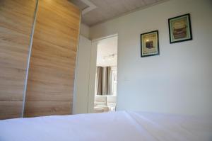 Un dormitorio con una cama blanca y un espejo. en Chalet d'Aventures, en Durbuy
