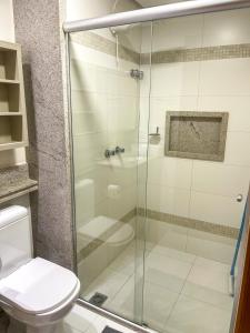 Un baño con ducha de cristal con inodoro. en Apartamento em palmas, en Palmas