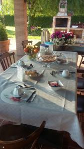 a table with a white table cloth with food on it at Casale Del Borgo in Hermada