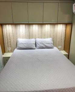 una cama con dos almohadas encima en Apartamento em palmas, en Palmas