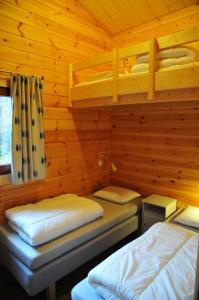 a bedroom with two beds in a log cabin at Abri Vert in Oignies-en-Thierache