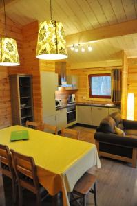 a kitchen and living room with a table and a couch at Abri Vert in Oignies-en-Thierache