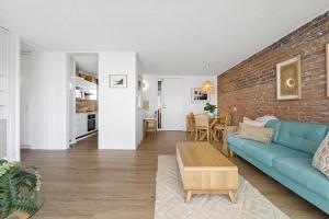 a living room with a blue couch and a brick wall at LOCATION, LOCATION! Walk to anywhere! in Gold Coast