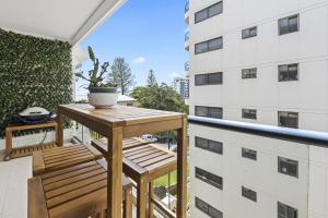 a small wooden table on the balcony of a building at LOCATION, LOCATION! Walk to anywhere! in Gold Coast