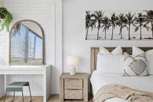 a bedroom with a bed with a mirror and palm trees at LOCATION, LOCATION! Walk to anywhere! in Gold Coast