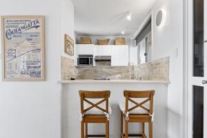 a kitchen with two chairs at a counter at LOCATION, LOCATION! Walk to anywhere! in Gold Coast +32 photos