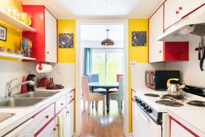 una cocina con paredes rojas y amarillas y una mesa. en Zilker Museum Home w King Bed, Patio Grill- Extended Stays Welcome, en Austin