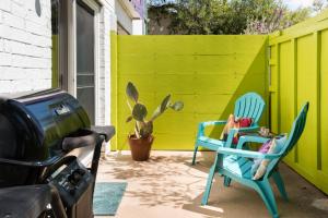 Dos sillas en un patio con una cerca verde. en Zilker Museum Home w King Bed, Patio Grill- Extended Stays Welcome, en Austin