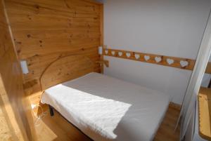 een kleine slaapkamer met een wit bed in een kamer bij Piolet Panoramic Apartments in Breuil-Cervinia