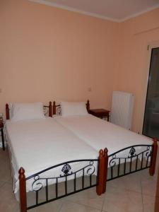 1 dormitorio con 1 cama grande con sábanas blancas en Villa Natura, en Agia Marina