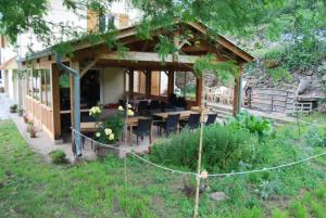 a house with a table and chairs in a yard at Mas Lluganas in Mosset