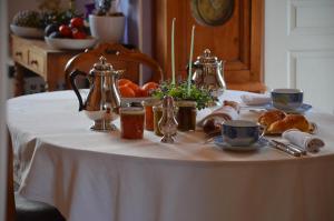 a table with a white table cloth with tea pots and croissants at La Minaudière 62 in Boulogne-sur-Mer