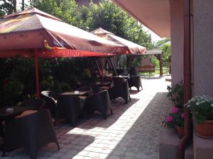 an outdoor patio with tables and chairs and umbrellas at Casa Mario in 2 Mai