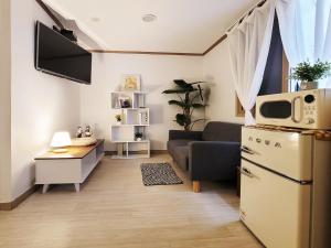 a living room with a refrigerator and a couch at G Hotel near Busan Station in Busan