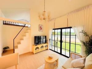 a living room with a staircase and a couch at Nordika Hill Resort by Alphatel in Pak Chong