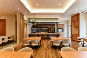 a restaurant with wooden tables and chairs and a bar at Hotel JAL City Miyazaki in Miyazaki