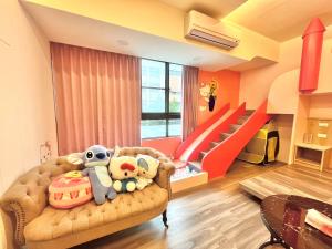 a living room with a couch with stuffed animals on it at 山田心溜滑梯民宿 in Chiang-hsi-shan-lin