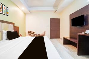 a hotel room with a bed and a tv at Super Townhouse Sikar Road Jaipur Formerly Hotel Aroma Inn in Jaipur +48 photos