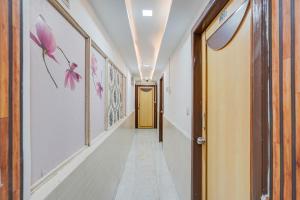 a corridor of a hallway with pink flowers on the walls at Super Collection O Maninagar East Formerly Maninagar Residency in Ahmedabad