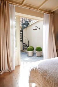 a bedroom with white curtains and two potted plants at B&B Maryline in Antwerp