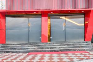 two glass doors of a red building with stairs at Super Townhouse AIIMS Kolkata Formerly Tanish Inn in Kalyani +26 photos