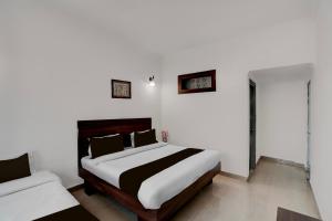 格德拉Super Collection O Vaishno Devi Temple Formerly Hotel The Leaf的一间卧室设有一张床和白色的墙壁