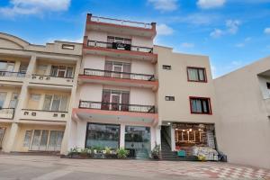 格德拉Super Collection O Vaishno Devi Temple Formerly Hotel The Leaf的一座高大的白色建筑,设有窗户和阳台