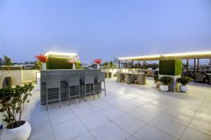 a rooftop patio with tables and chairs on a building at Saltstayz Premier - Galleria Market Road & Sector 27 in Gurgaon