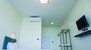 a bedroom with a bed and a television on a wall at Phala Shore Resort in Ban Phala