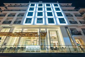 Edificio alto de color blanco con balcón en Hotel Valentina, en San Julián