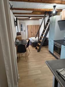 a room with a table and a kitchen with a staircase at Apartamenty Stara Cegła in Zgorzelec