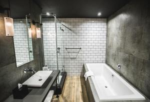 a bathroom with two sinks and a bath tub at Century City Hotel Urban Square in Cape Town +31 photos